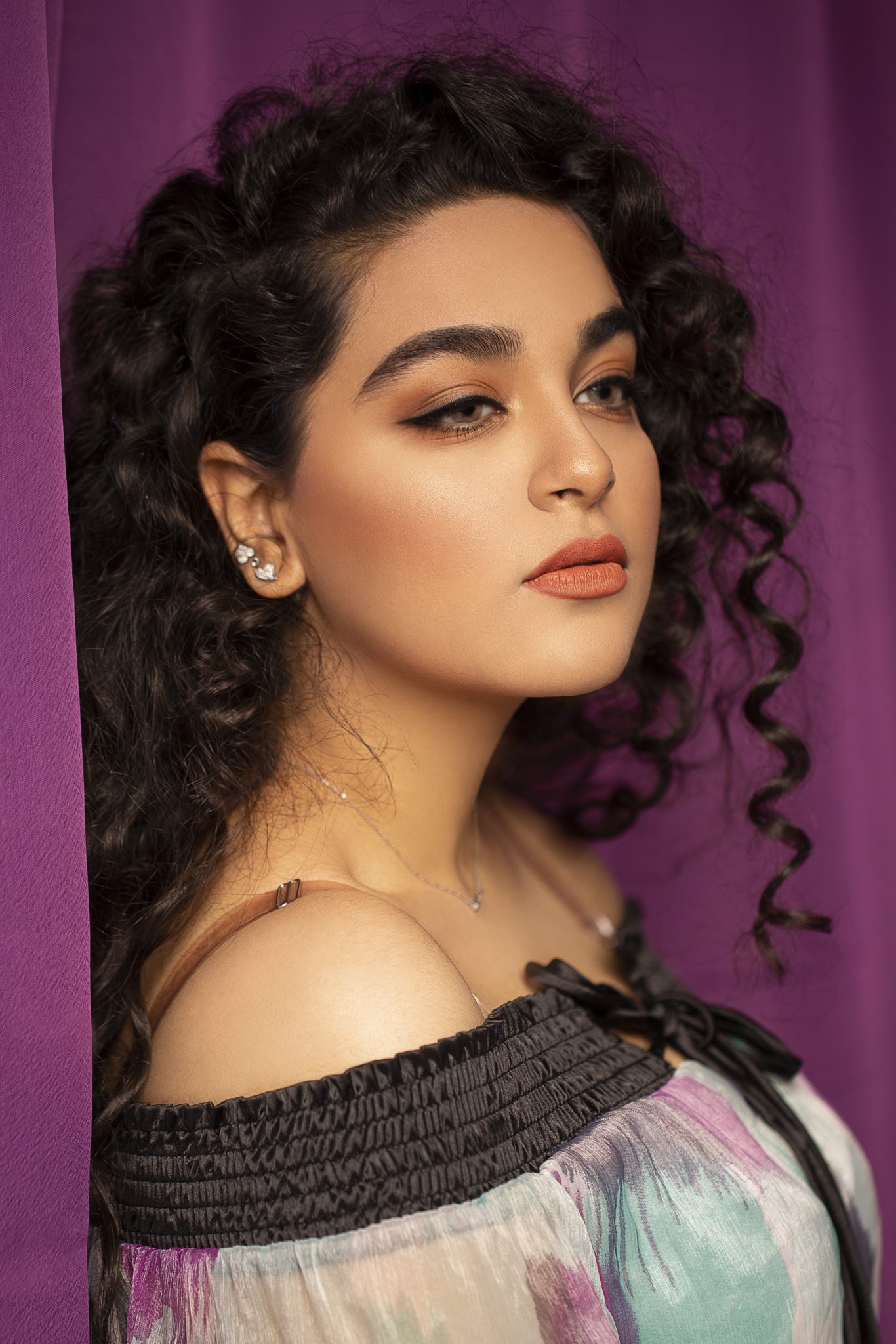 fashion model with curly black hairs and light makeup